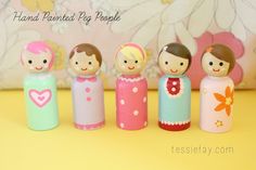 a group of small wooden dolls standing next to each other in front of a flowered wall