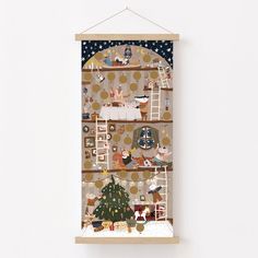 a wooden frame hanging on the wall above a christmas tree with cats and other decorations