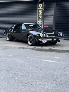 a black car parked in front of a garage door