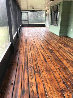 an empty porch with wood floors and windows