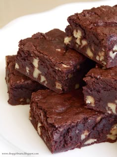 a white plate topped with brownies covered in nuts