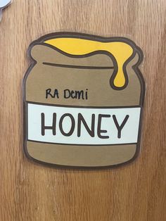 a sticker that says honey on the side of a wooden door with a jar of honey