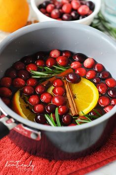 a pot filled with cranberries and orange slices