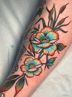 a colorful flower tattoo on the leg