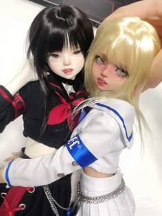 two dolls are posed next to each other