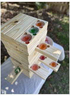 a stack of wooden pegs with different colored buttons on them sitting in the grass