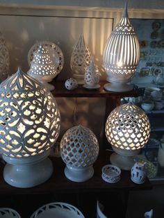 many white vases and bowls on a shelf