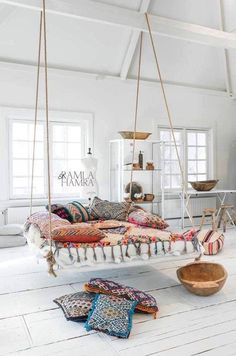 a living room filled with lots of furniture and hanging items on the ceiling above it