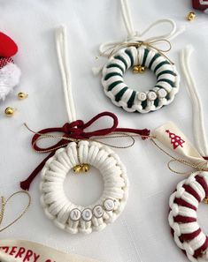 christmas ornaments are displayed on a table with red and white ribbons, ornaments