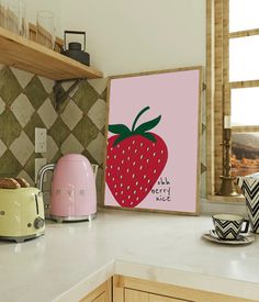 a kitchen counter with toaster, kettle and strawberry painting on the wall above it