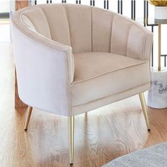 a beige chair sitting on top of a hard wood floor next to a white rug