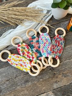 three pairs of scissors sitting on top of a wooden table next to plants and yarn