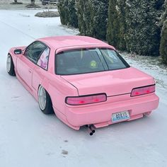 a pink car is parked in the snow