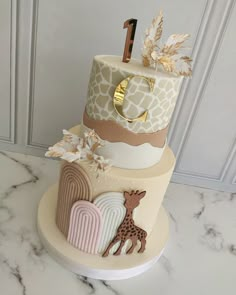 a three tiered cake decorated with giraffes and leaves