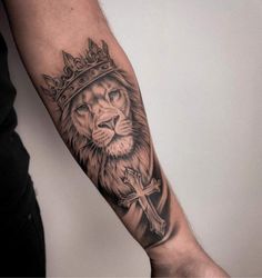 a lion with a crown tattoo on his arm