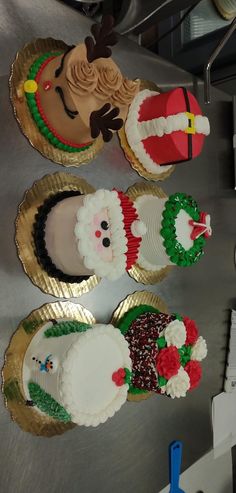 three decorated cupcakes sitting on top of a metal counter next to each other