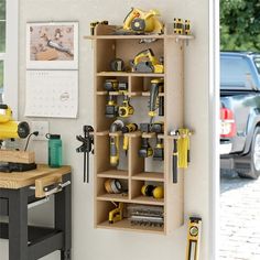 a workbench with tools on it in front of a wall mounted tool organizer