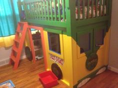 a child's play house made out of cardboard and painted green, yellow and red