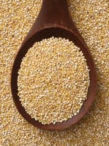 a wooden spoon filled with grain on top of a carpet