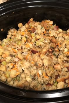 a crock pot filled with stuffing and vegetables