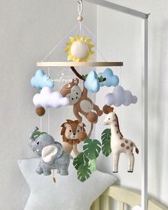 a crib mobile with stuffed animals and giraffes hanging from it's sides