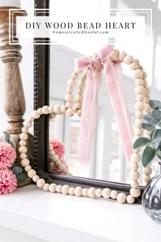 a wooden bead heart frame sitting on top of a white mantle