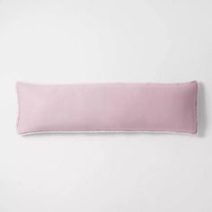 a pink pillow on a white wall with a light pink border around the edge,