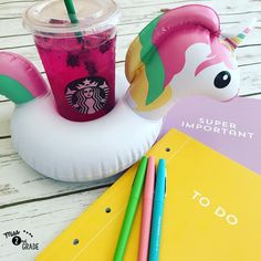 a unicorn shaped drink in a plastic cup with straws next to it