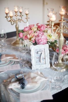 the table is set with flowers, candles and plates for an elegant dinnereon party