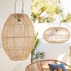 two rattan style hanging baskets on the wall next to a chair and potted plant