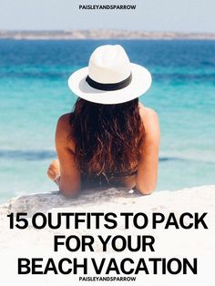 the back of a woman wearing a white hat sitting on top of a sandy beach