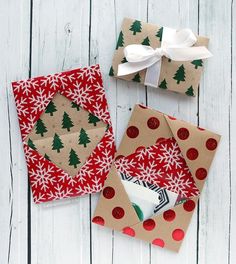 wrapping presents on a white wooden surface with christmas trees and snowflakes around them