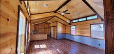 an empty room with wood flooring and ceiling fan