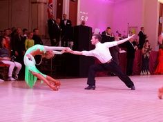 two people dancing on a dance floor in front of an audience