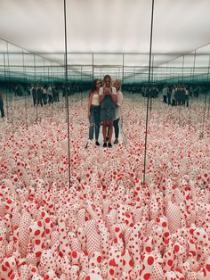 three girls standing in front of mirrors with red and white polka dots on the ground