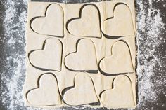 heart shaped cookie cutters laid out on top of a baking sheet, ready to be baked