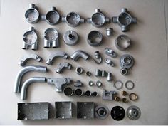 various metal parts are laid out on a table top, including pipes and fittings