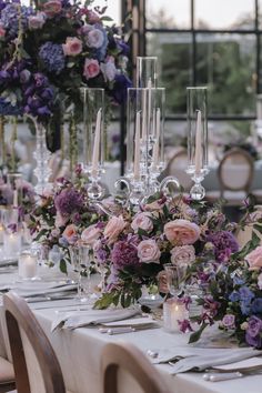 the table is set with candles, flowers and wine glasses for an elegant wedding reception