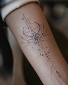 a woman's arm with a tattoo on it that has an arrow and stars