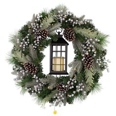 a christmas wreath with pine cones, evergreens and a lantern hanging from the front