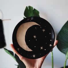 a person holding up a black and white plate with stars in the sky on it