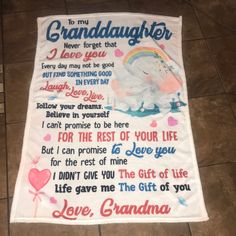 a blanket with the words granddaughter and an elephant in rainbow colors on it, sitting on a tile floor