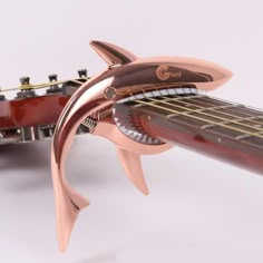 a close up of a guitar with a dolphin decoration on it's back end