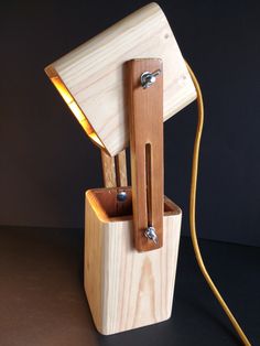 a wooden lamp that is sitting on top of a table next to a light bulb