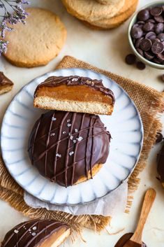 two chocolate covered cookies on a plate next to other desserts