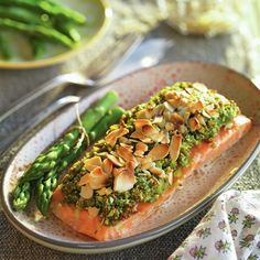 a plate topped with salmon and asparagus on top of a table