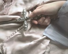 a person is holding a cross in their hand