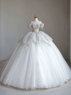 a white wedding dress on display in front of a window with an empty dummye behind it