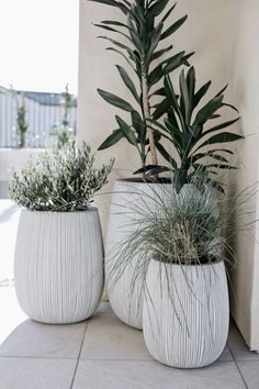 two white planters sitting on top of a tiled floor