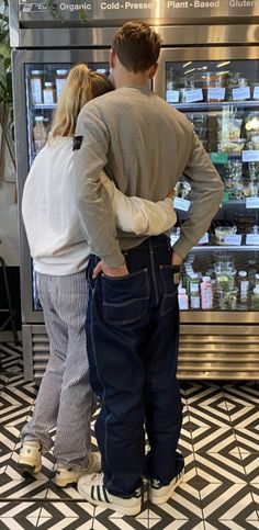 two people standing in front of a display case